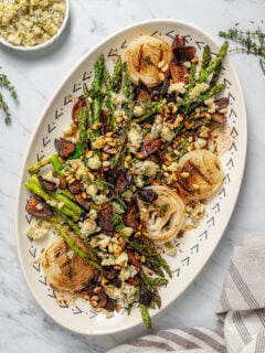An asparagus salad with toppings and vinaigrette.